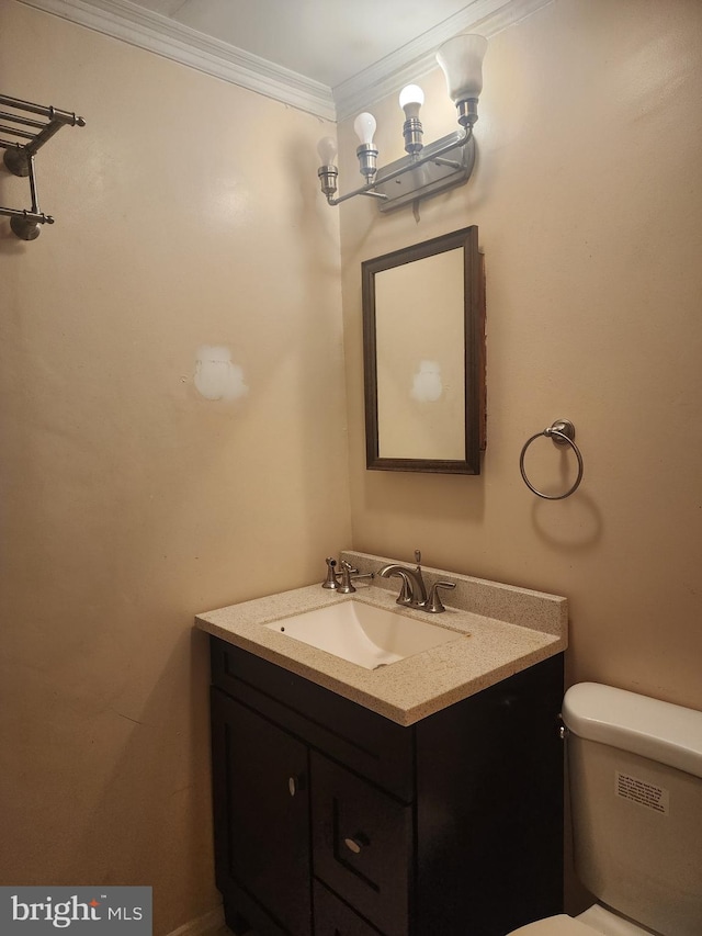 bathroom featuring ornamental molding, vanity, and toilet