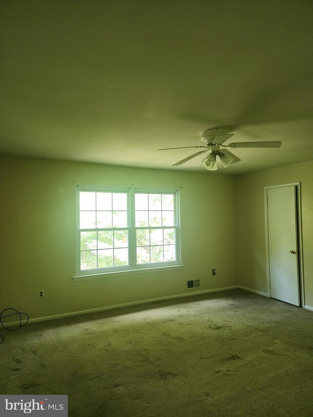 carpeted spare room with ceiling fan