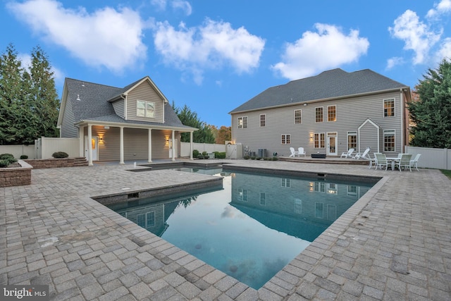 back of house with a fenced in pool and a patio area