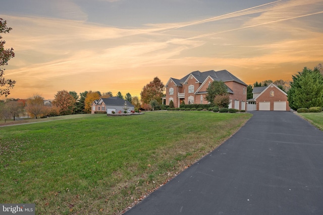 view of front of property with a garage and a yard