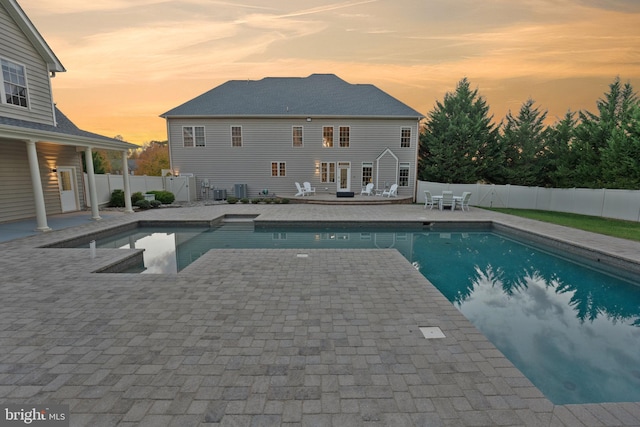 pool at dusk featuring a patio