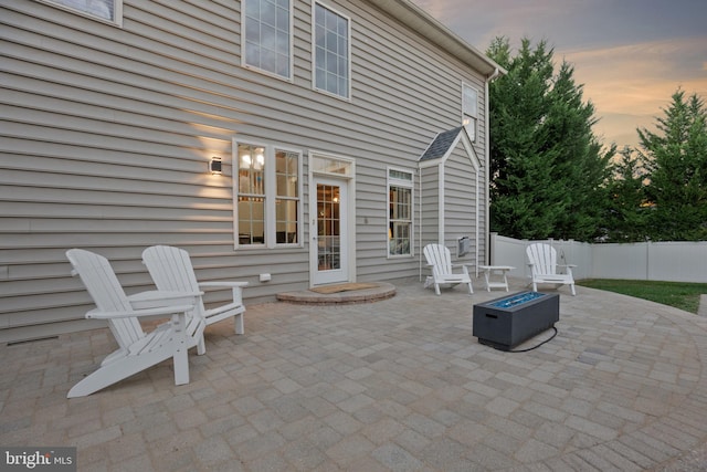 patio terrace at dusk featuring a fire pit