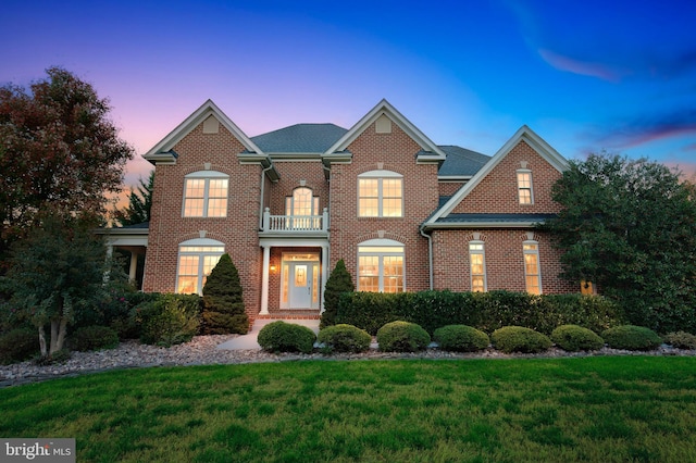 view of front of property with a balcony and a yard