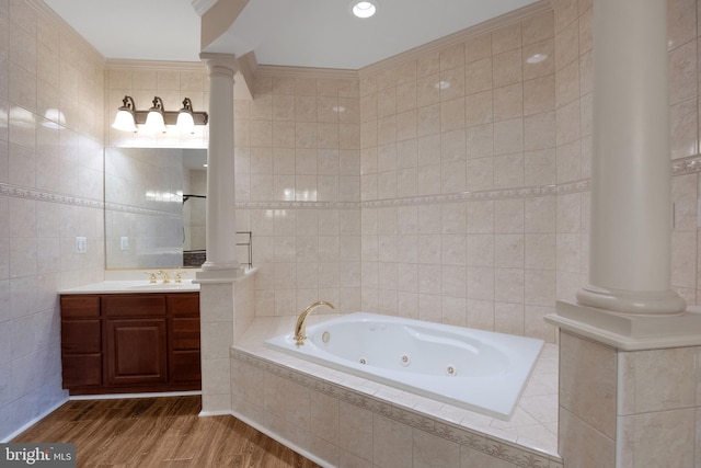 bathroom with tile walls, wood-type flooring, a relaxing tiled tub, and ornamental molding