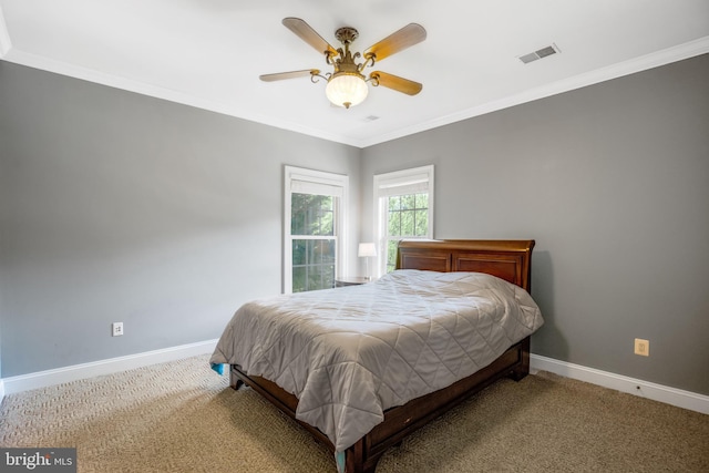 carpeted bedroom with ornamental molding and ceiling fan