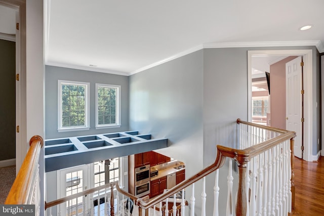 stairway with hardwood / wood-style flooring and ornamental molding