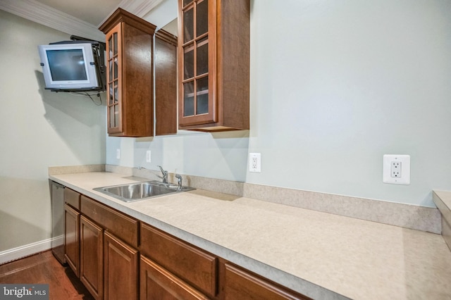 kitchen featuring dark hardwood / wood-style floors, crown molding, sink, and dishwasher