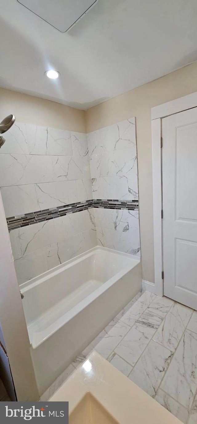 bathroom featuring recessed lighting, marble finish floor, and washtub / shower combination