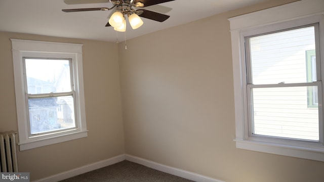 spare room featuring radiator, baseboards, carpet floors, and ceiling fan