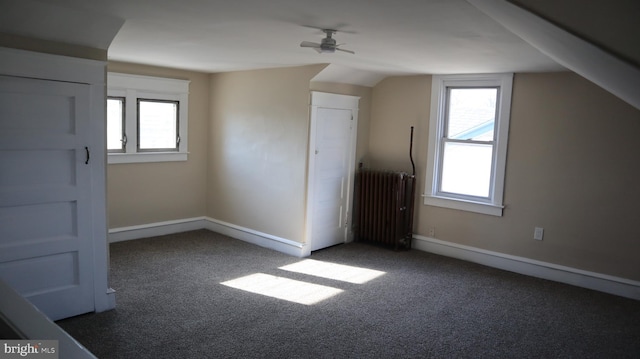 bonus room with carpet flooring, radiator, a ceiling fan, and baseboards