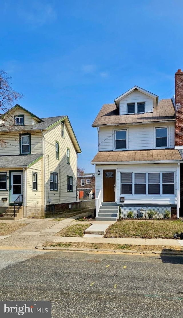 american foursquare style home with entry steps and a chimney