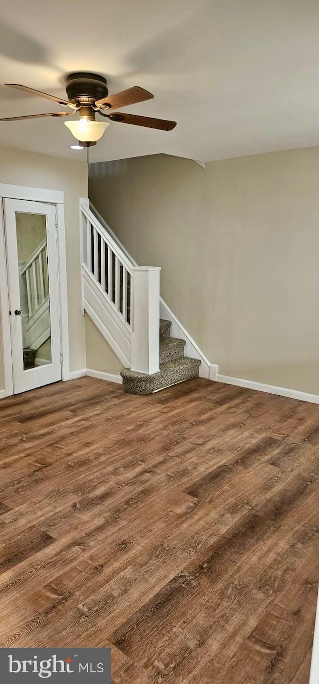 stairway with baseboards, ceiling fan, and wood finished floors