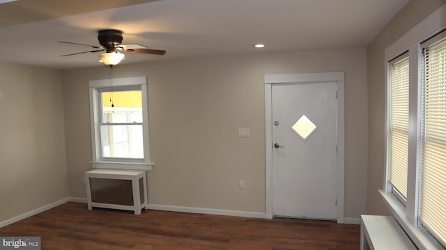 foyer entrance with baseboards, ceiling fan, and dark wood-style flooring