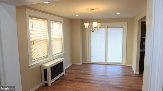 unfurnished dining area featuring recessed lighting, a healthy amount of sunlight, a chandelier, and radiator heating unit