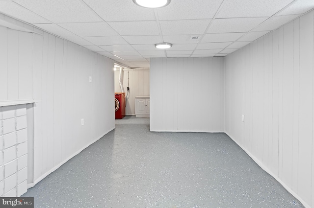 basement with a drop ceiling and washing machine and dryer