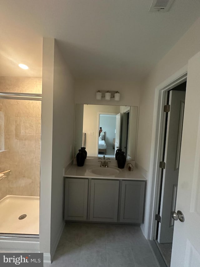 bathroom with tile patterned flooring, walk in shower, and sink