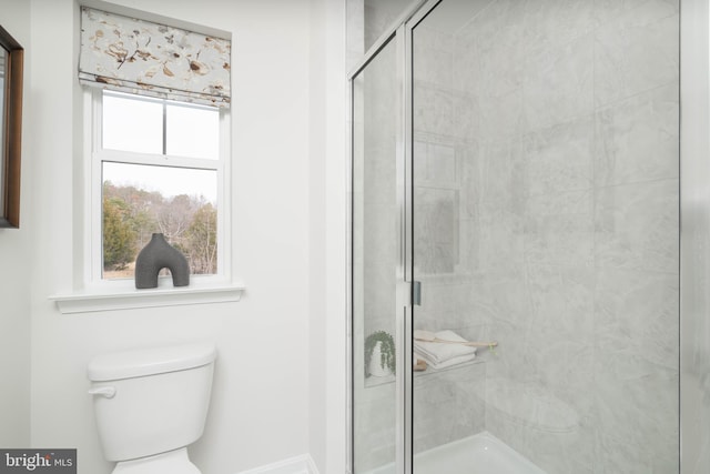 bathroom with toilet and a shower with door