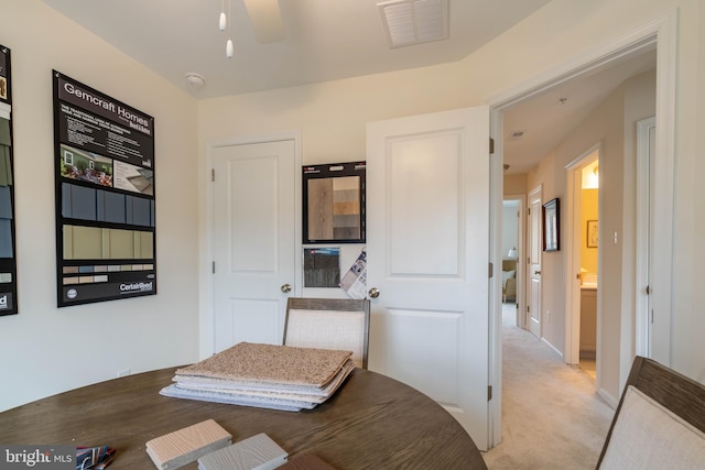 bedroom with ceiling fan, light colored carpet, and connected bathroom