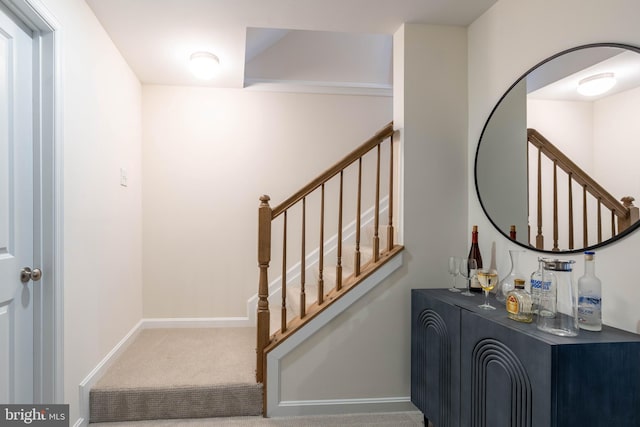 staircase featuring carpet floors and bar area