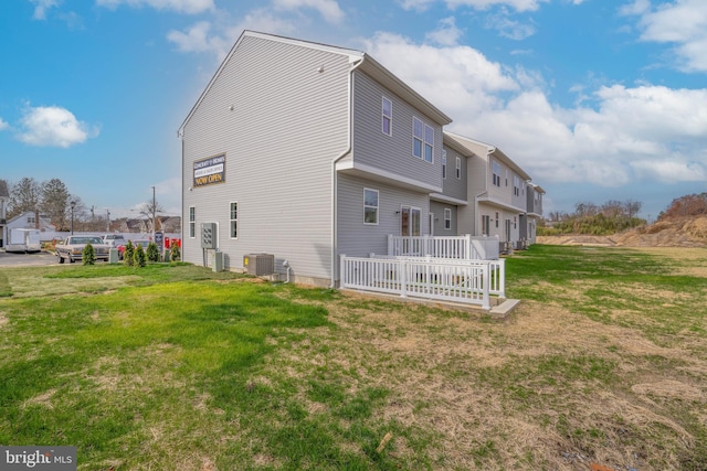 back of property featuring a lawn and central AC