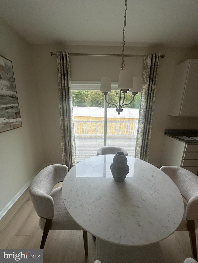 dining space featuring light hardwood / wood-style flooring and a notable chandelier