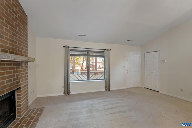 unfurnished living room with lofted ceiling, a fireplace, and light carpet