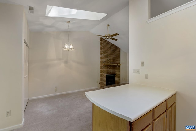 kitchen with a fireplace, ceiling fan with notable chandelier, a skylight, decorative light fixtures, and light colored carpet