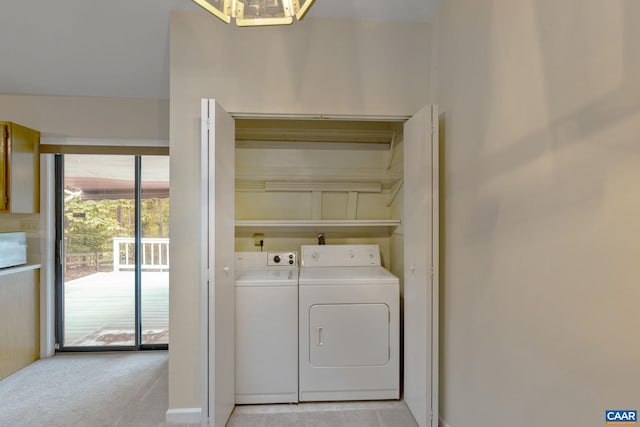 clothes washing area featuring light colored carpet and washer and clothes dryer