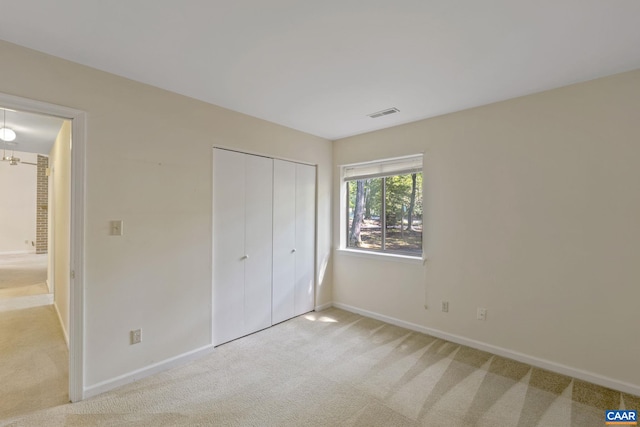 unfurnished bedroom featuring a closet and light carpet