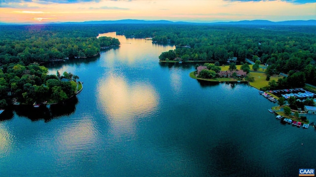 aerial view at dusk featuring a water and mountain view