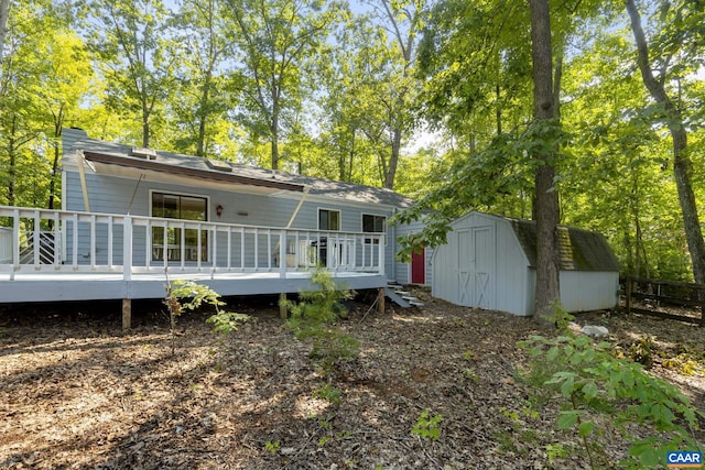 back of property featuring a deck and a storage unit