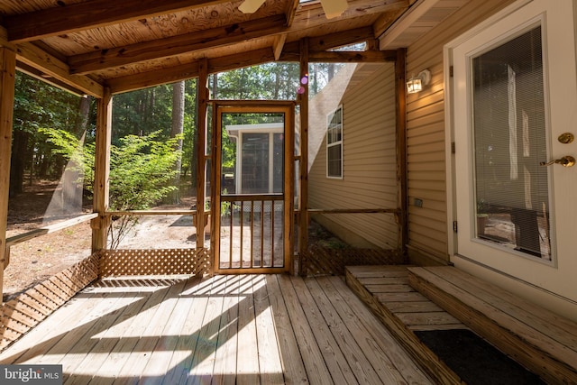 unfurnished sunroom with ceiling fan and lofted ceiling with beams