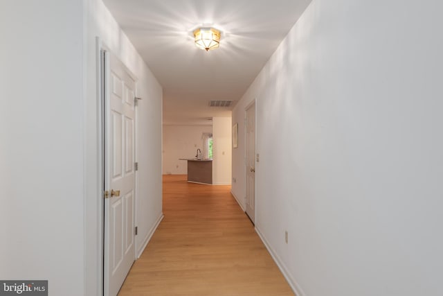 hallway with light hardwood / wood-style floors