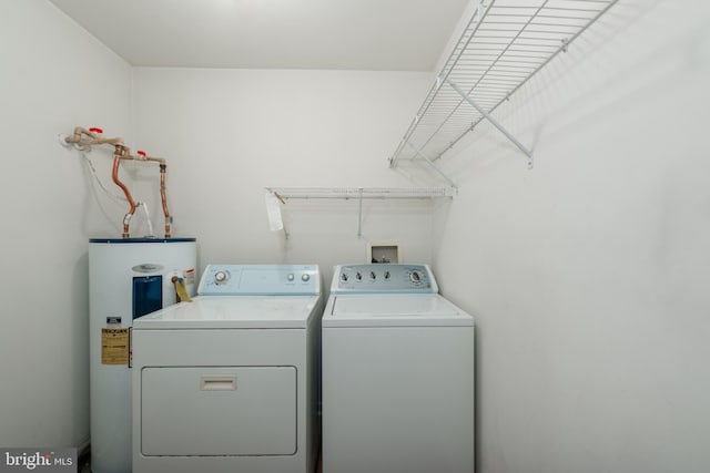 clothes washing area featuring separate washer and dryer and water heater