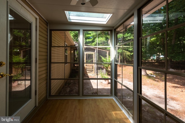 unfurnished sunroom featuring ceiling fan and lofted ceiling with skylight