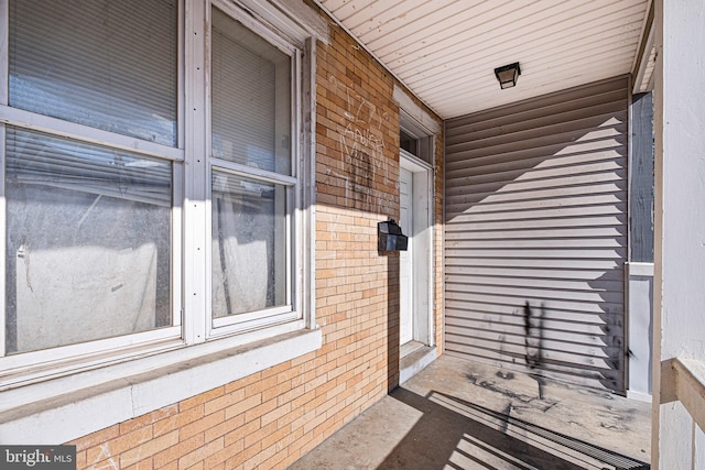 view of exterior entry featuring brick siding