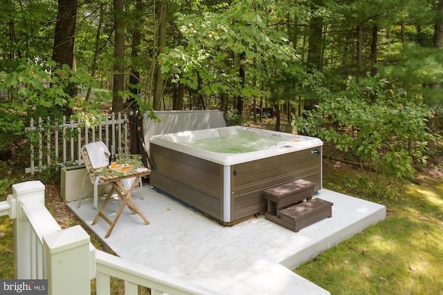 wooden terrace featuring a hot tub and a patio