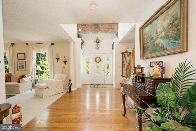 entryway with a textured ceiling and light wood-type flooring