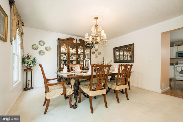 carpeted dining room with a chandelier