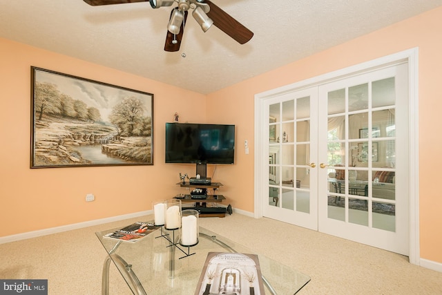 living room featuring a textured ceiling, carpet flooring, ceiling fan, and french doors