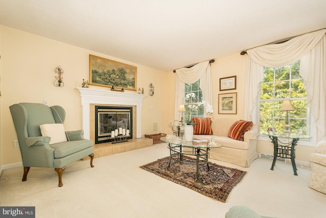 living room with a tiled fireplace and light carpet