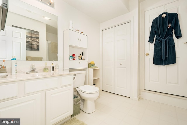 bathroom with tile patterned flooring, vanity, toilet, and a shower with shower door