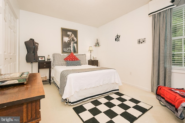 bedroom featuring light carpet, multiple windows, and a closet