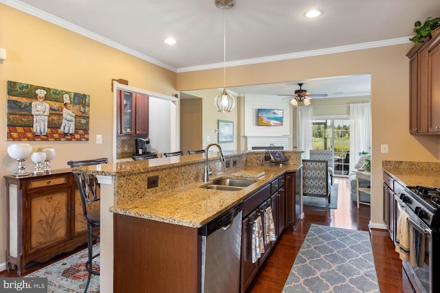 kitchen featuring glass insert cabinets, a kitchen breakfast bar, a sink, black gas stove, and stainless steel dishwasher