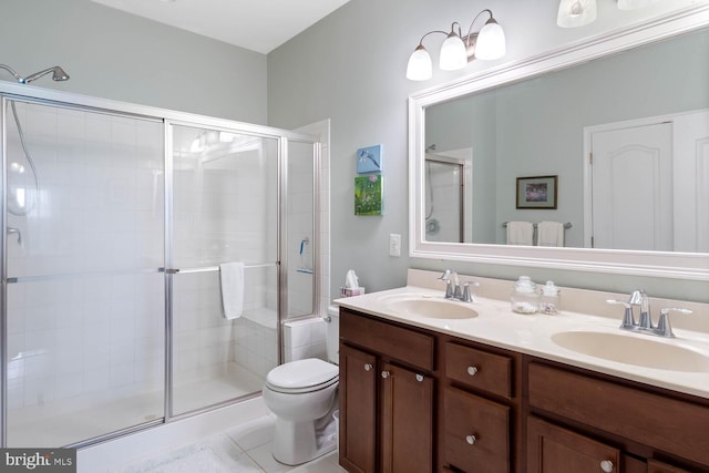 full bath with toilet, a stall shower, double vanity, and a sink