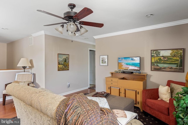 living room with ceiling fan, wood finished floors, visible vents, baseboards, and ornamental molding