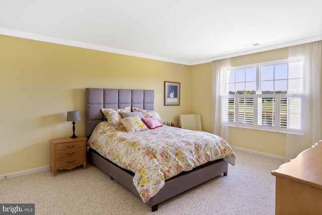 bedroom with baseboards, crown molding, and light colored carpet