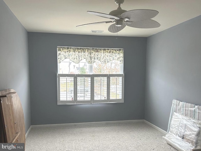 spare room with carpet floors, visible vents, baseboards, and ceiling fan