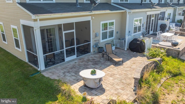 rear view of property with a patio area and a sunroom