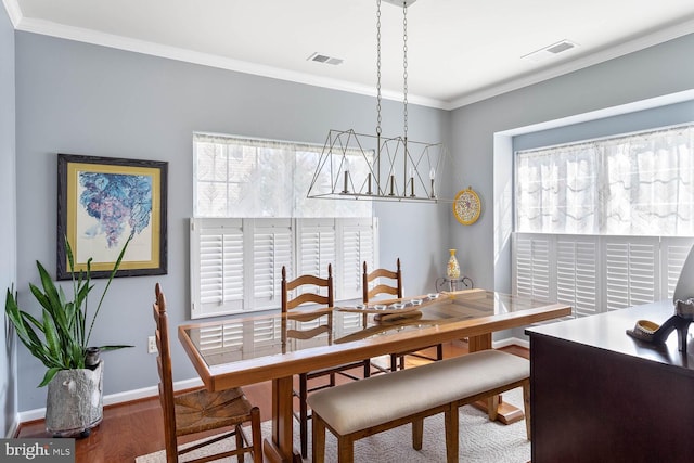 dining space with visible vents, crown molding, baseboards, and wood finished floors